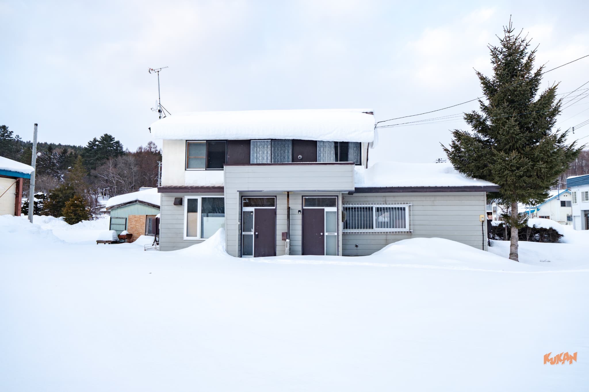 北海道富良野市東山地區的 2 層木造住宅外觀，展示獨特的雙門入口。